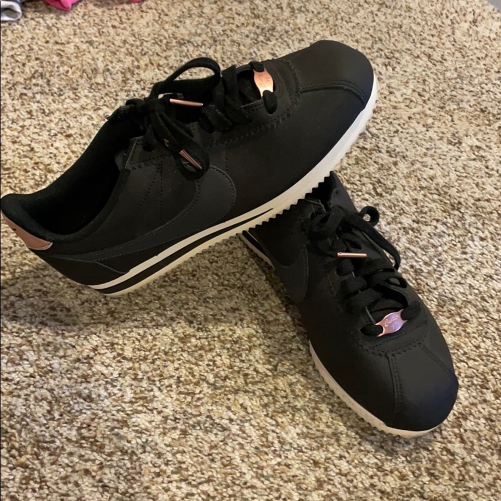 Black Nike Cortez sneakers with rose gold